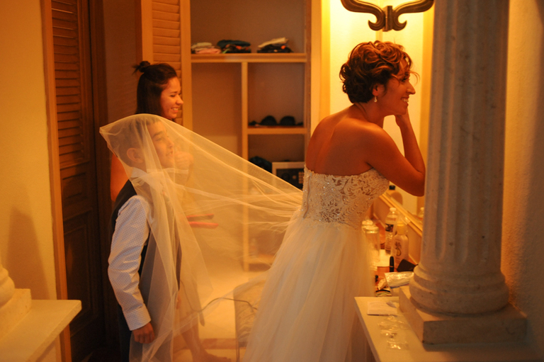 Niño jugando con el vestido de novia de su mamá