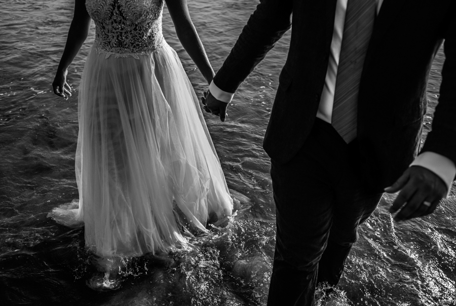 Recién casados caminando en el mar