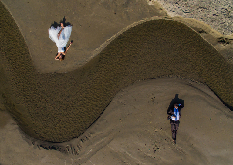 Foto de novios acostados hecha con dron en boca de iguanas