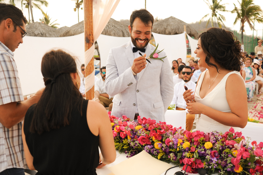 Los novios sonriendo y firmando