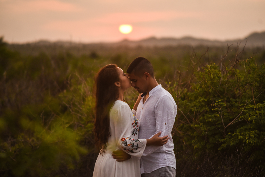 Novia besando a su novio en el atardecer